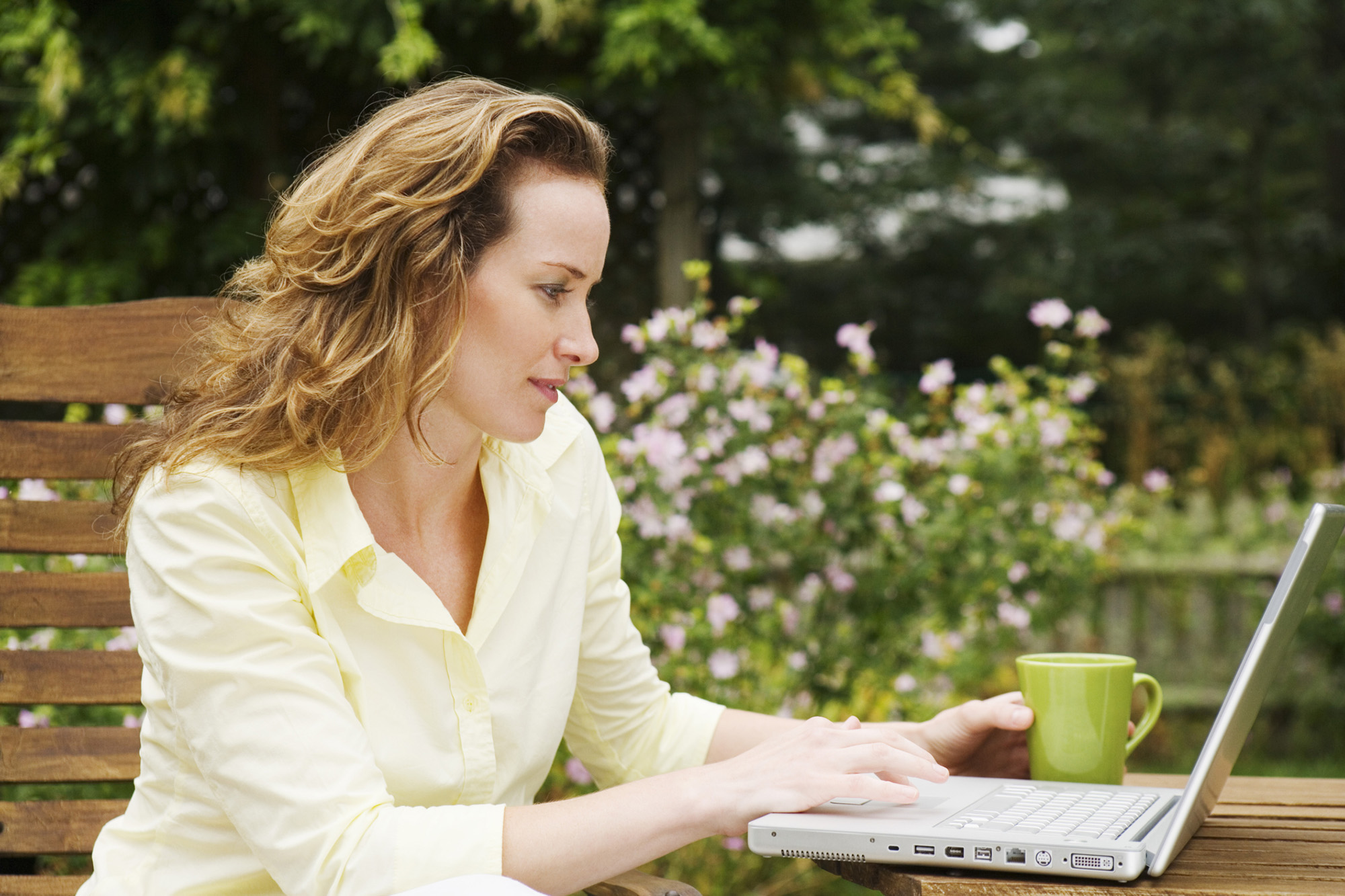 Woman on laptop computer outdoors at Tuscany Santa Clara